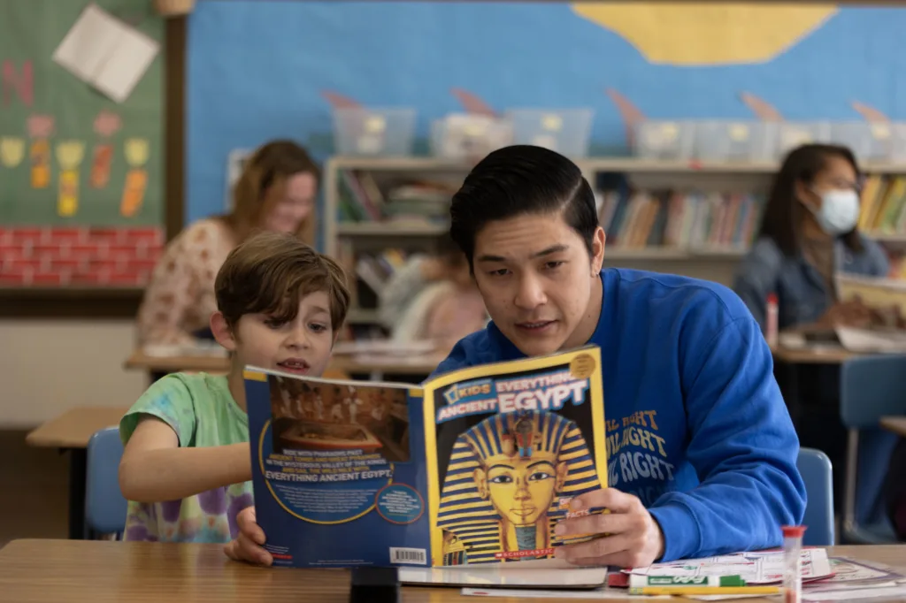 tutor and student reading a national geographic book together