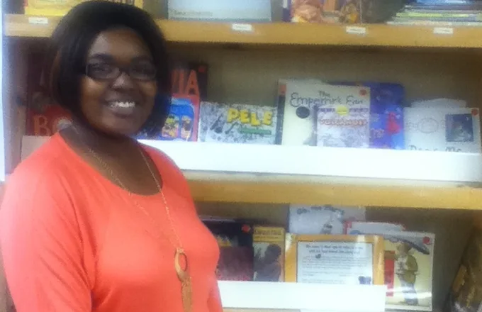 tutor standing in front of bookshelves