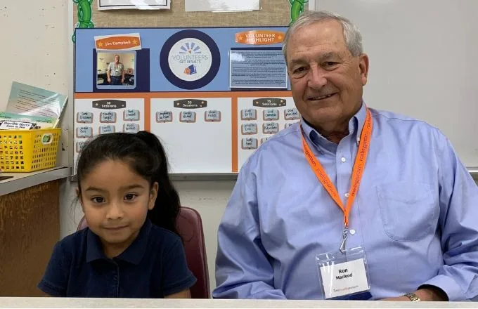 volunteer tutor smiling with student