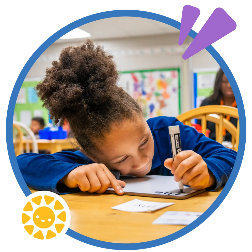 a student writing on a whiteboard as she practices her letters and words; free tutoring in Newark