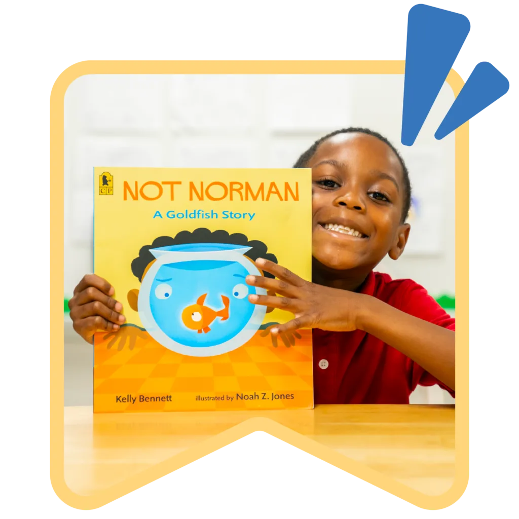 student holding up a book and smiling