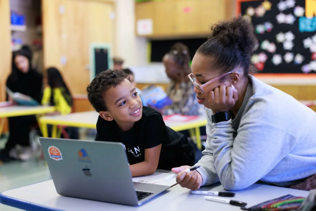 a tutor-student pair using reading partners connects, our innovation, on a computer in a reading center
