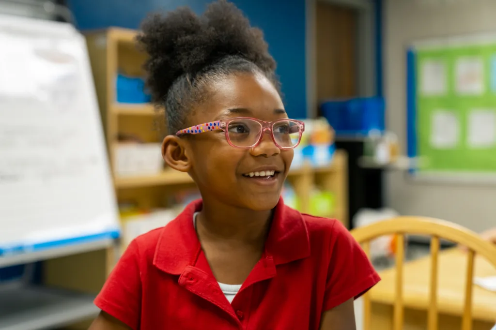 a student smiling to someone off camera; it takes a village to learn