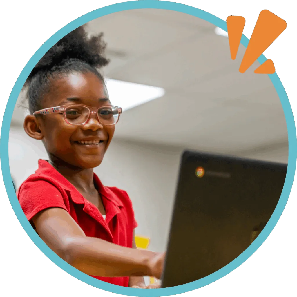volunteer with brilliant detroit; student pointing at laptop