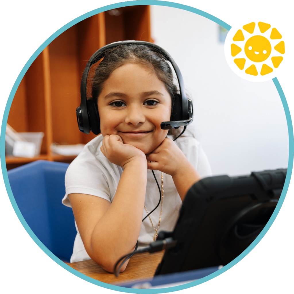 student smiling at the camera during a reading partners connects lesson