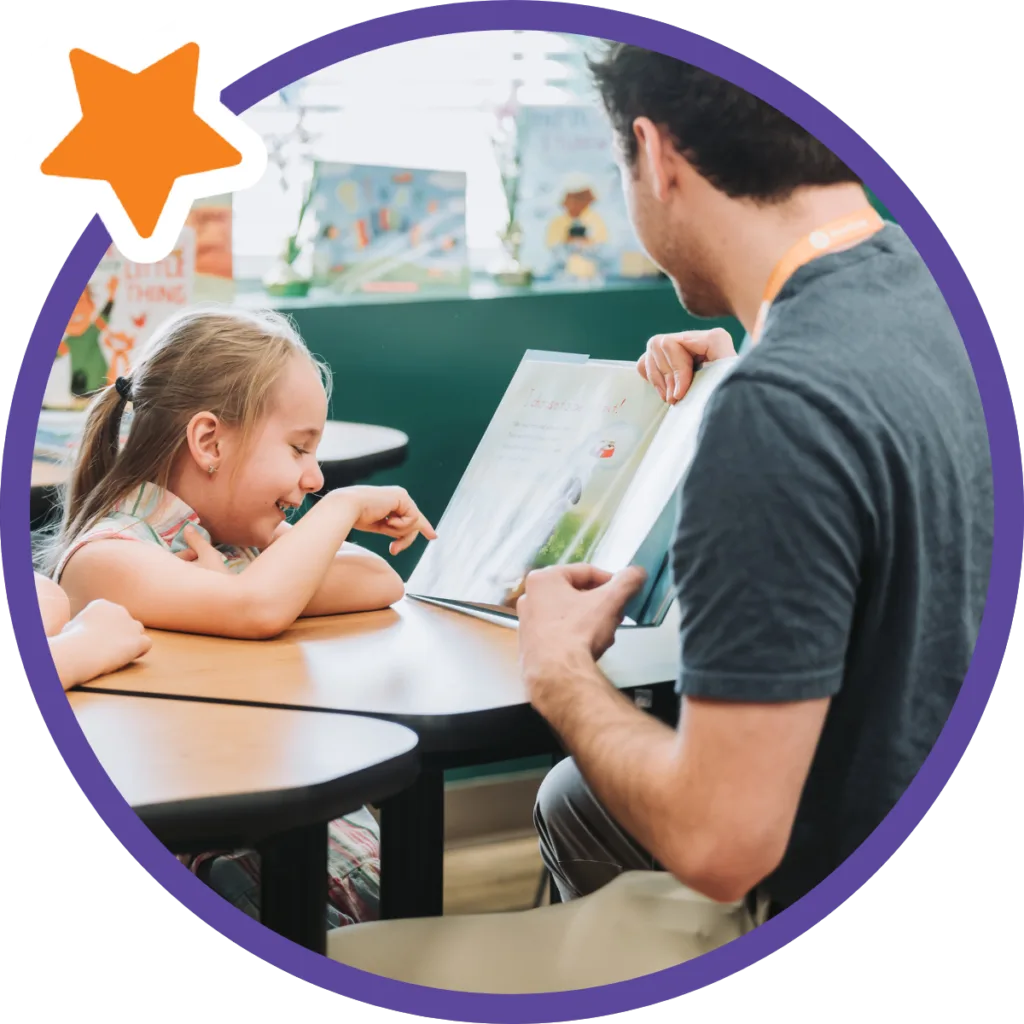student pointing at book and smiling