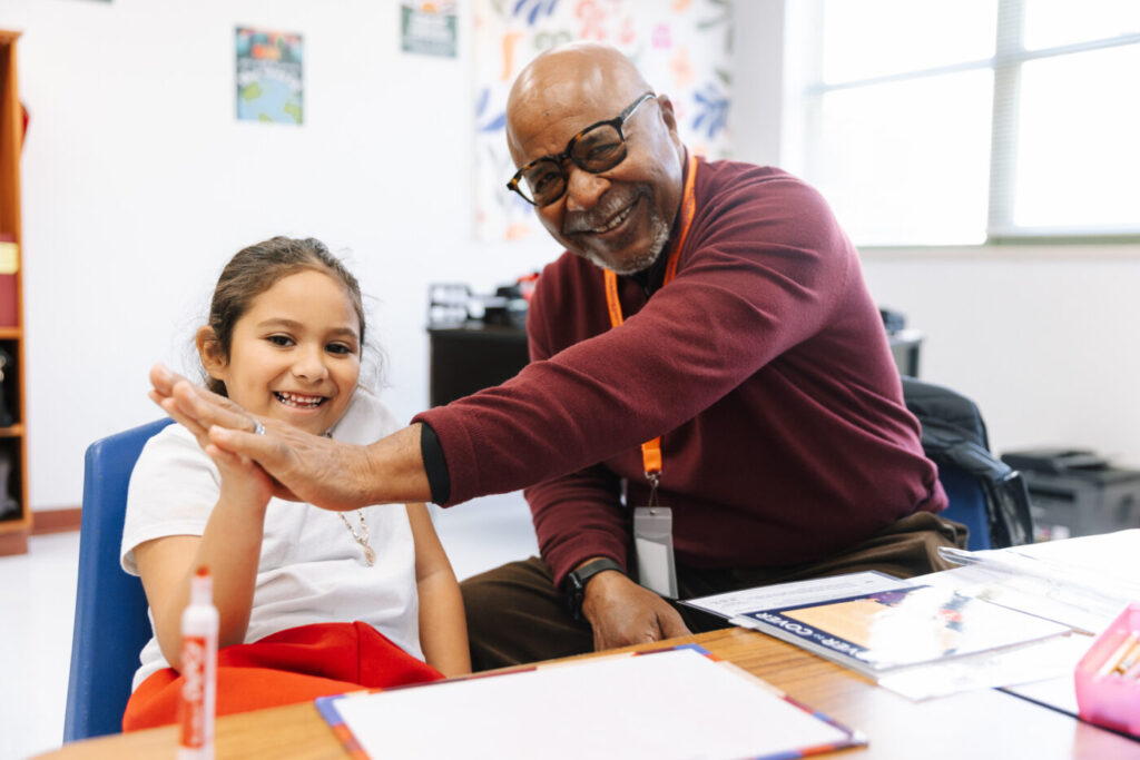 a tutor and student hihg-fiving